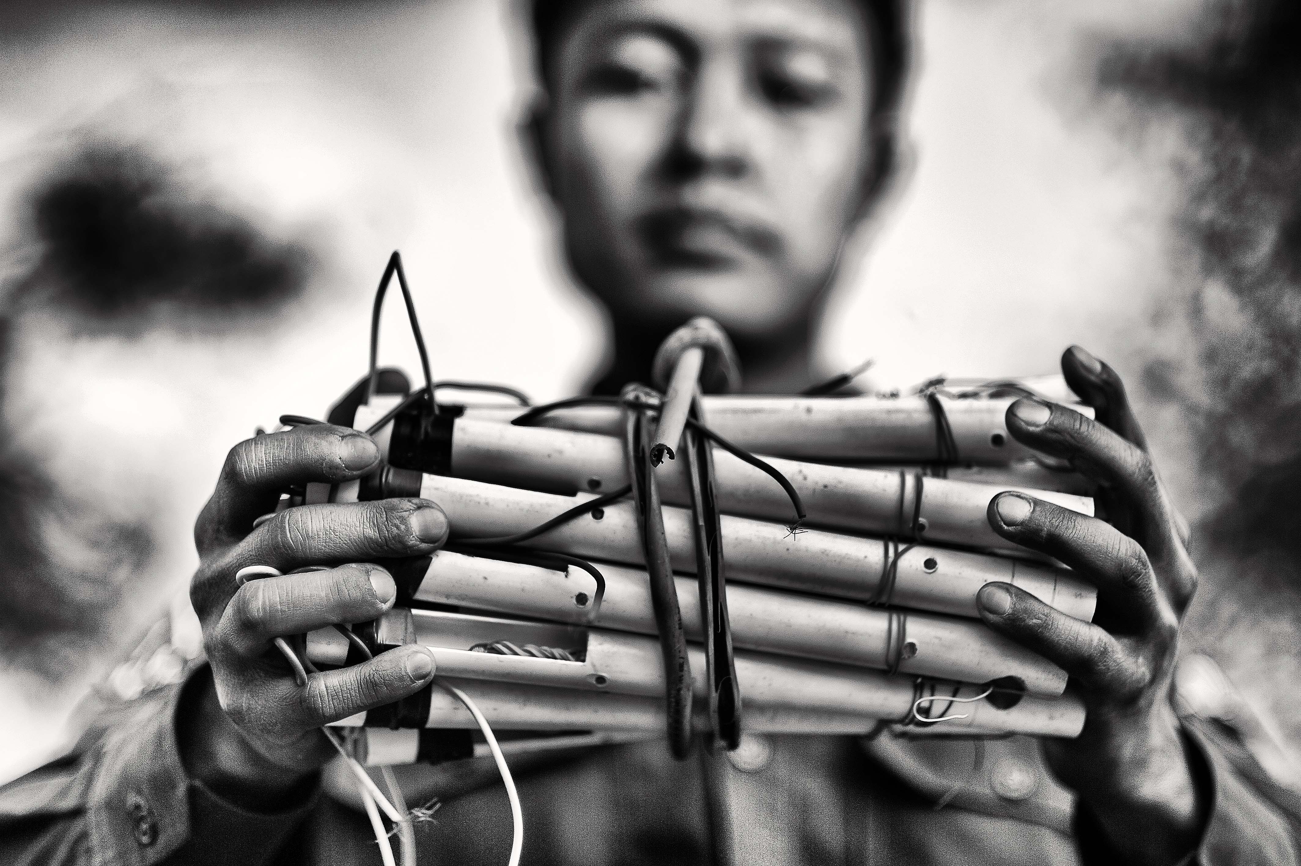 A Kachin Independence Army soldier holds landmines that he made at a front line army camp. Two weeks later, he was killed after one exploded while planting it in the jungle.