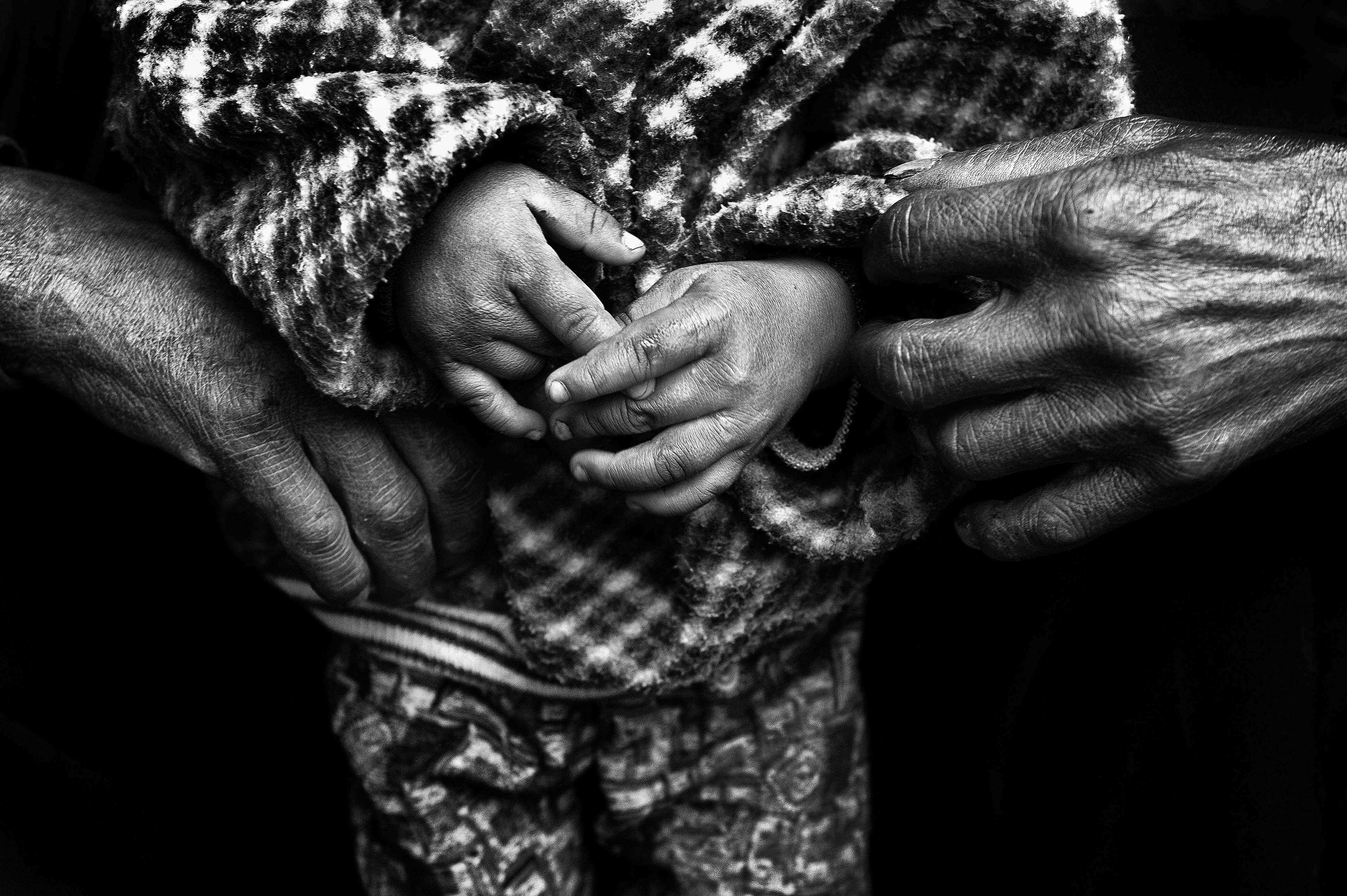 A father holds his son in an internally displaced camp in eastern Kachin State.